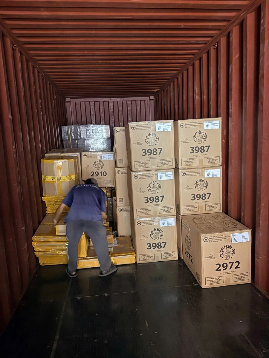 Cartons being loaded into a container by hand